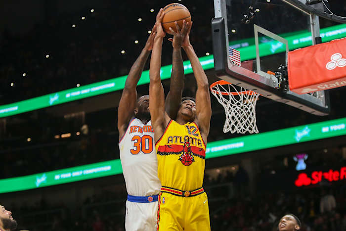 New York Knicks forward Julius Randle (30) and Atlanta Hawks forward De'Andre Hunter (12) reach for a rebound.